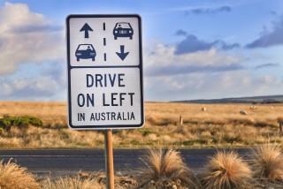 A road sign reading "Drive on left in Australia".