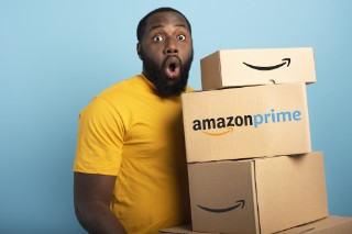 Surprised Man holds a lot of Amazon prime packages. Cyan background