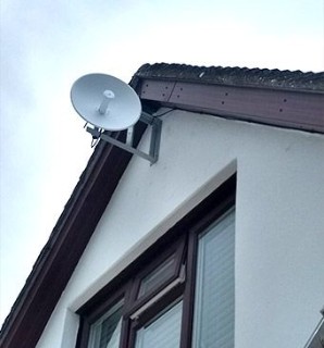 image showing a fixed wireless access receiver attached to the outside of a house