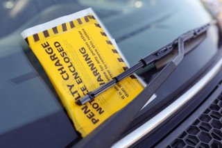 Penalty charge notice parking fine attached to car windscreen