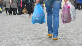 image of person carrying shopping in plastic bags