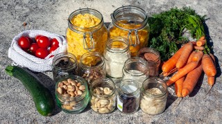 Vegetables laid out on a work surface, including carrots and tomatoes