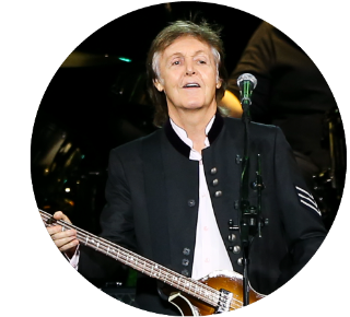 Paul McCartney Paul McCartney smiling onstage while holding a bass guitar.