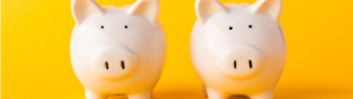Two white piggy banks on a yellow background