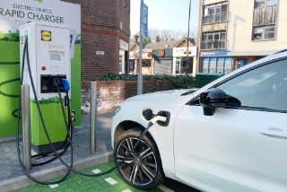 EPSOM, SURREY, UK - CIRCA MARCH 2022: An electric vehicle is being charged by a rapid charger at a supermarket.