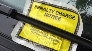 Close up of a Penalty Charge Notice under the windscreen wiper of a vehicle.