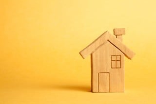 Homemade wooden house on a yellow background