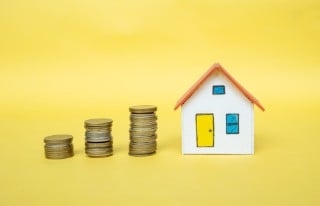 House model and coin money on yellow background,finance and banking concept,Minimal creative style.
