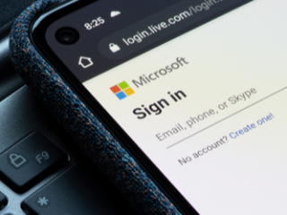 Close up of the Microsoft sign in page displayed on a smartphone laying on a laptop keyboard.