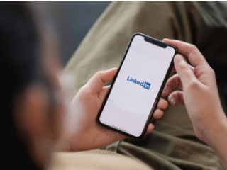 LinkedIn on a smartphone Close up on a woman looking at LinkedIn on a smartphone held in her lap.