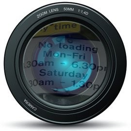 Close up of a camera zoom lens with a 'no loading' sign reflected in it.