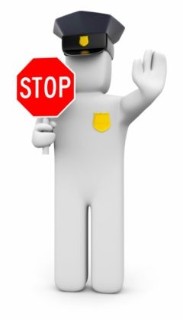 Plain white figure wearing a police hat and badge holding up a red 'stop' sign.