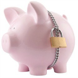 Pink piggy bank with a silver chain around it locked with a gold padlock.