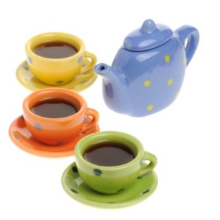 Three cups filled with black tea on three saucers with a teapot next to them.