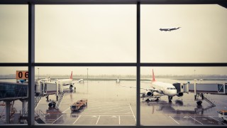 image of airport runway through terminal window
