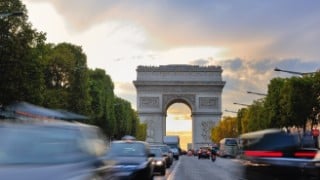 Blurred traffic with the Arc de Triomphe in Paris, France in the background.
