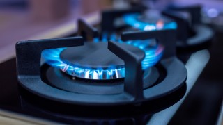Two lit gas hobs. The flames glow blue.