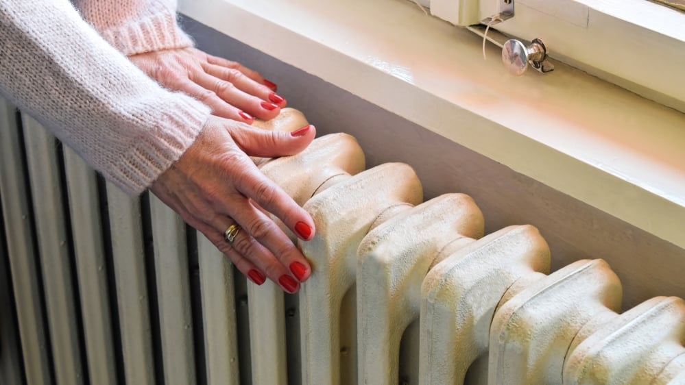 image of hands on central heating radiator