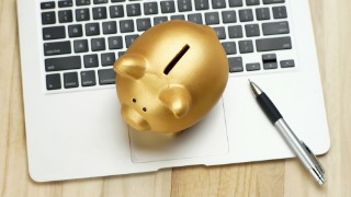 Golden piggy bank and pen on notebook. financial concept