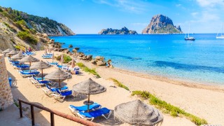 Sunbeds and parasols on a beach in Ibiza, Spain.