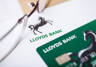 LONDON, UK - AUGUST 18, 2018: Lloyds Banking Group statement and credit card with glasses.