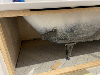 A bathtub with a small metal appendage attached to the side
