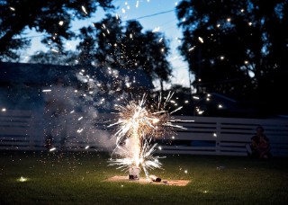 Fireworks in a garden, watched by two people