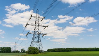 Electricity pylons in a field with blue sky. Much Hadham. Hertfordshire. UK